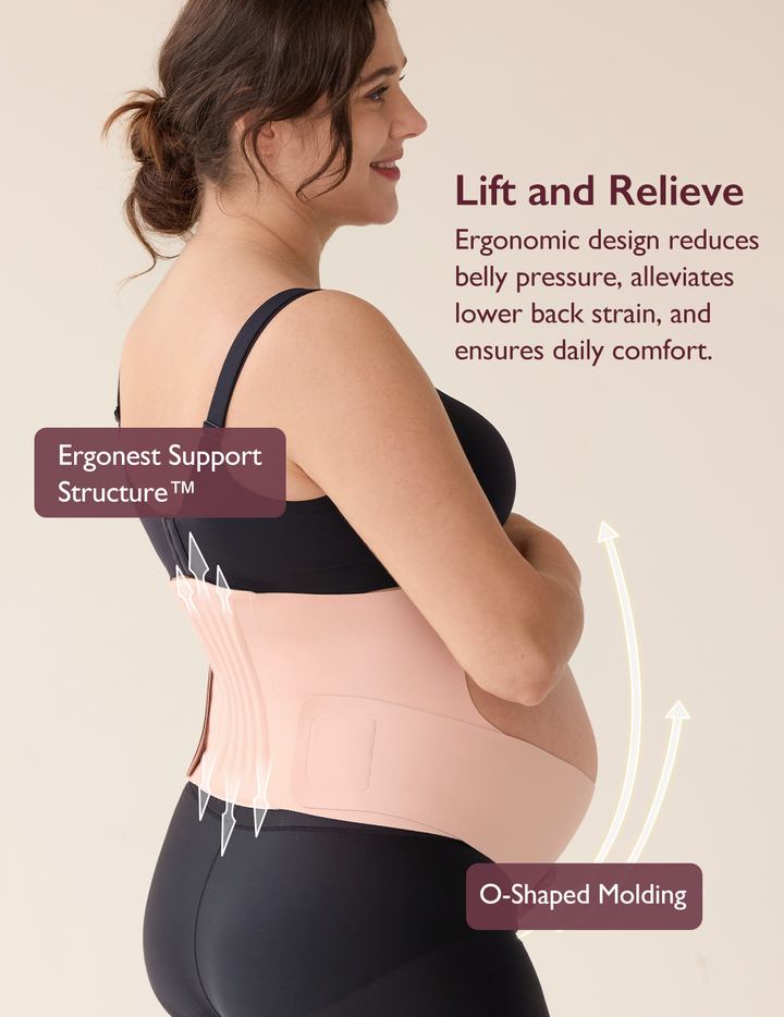 A pregnant woman wearing the oyster pink Momcozy Ergonest Maternity Belly Band demonstrates its ergonomic support design, which reduces pressure to ensure comfort.