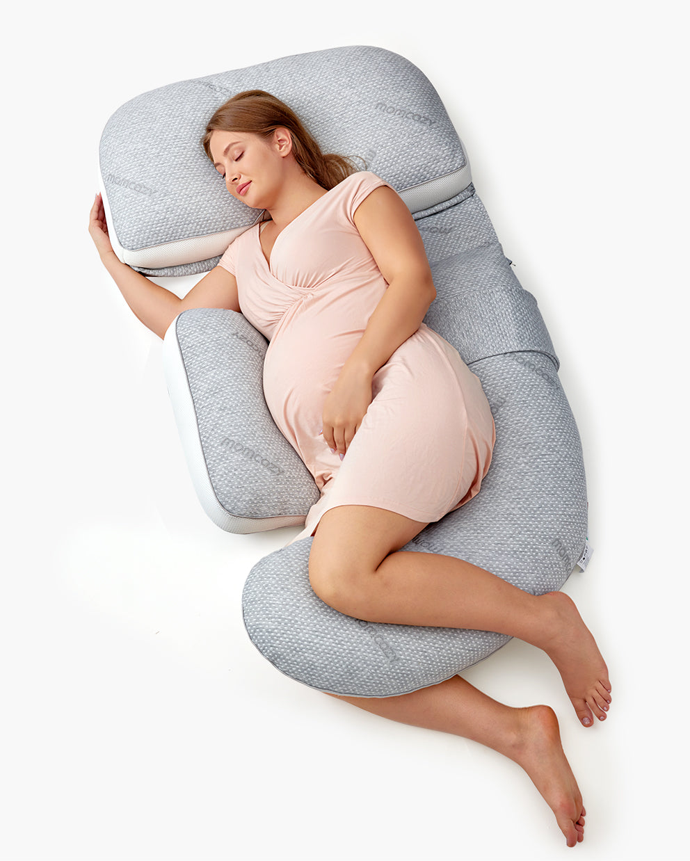 Pregnant woman relaxing with G Shaped Pro Pregnancy Pillow for cushioned support.