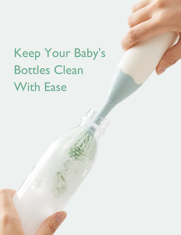 Momcozy bottle brush in action, cleaning baby bottle with foaming solution.