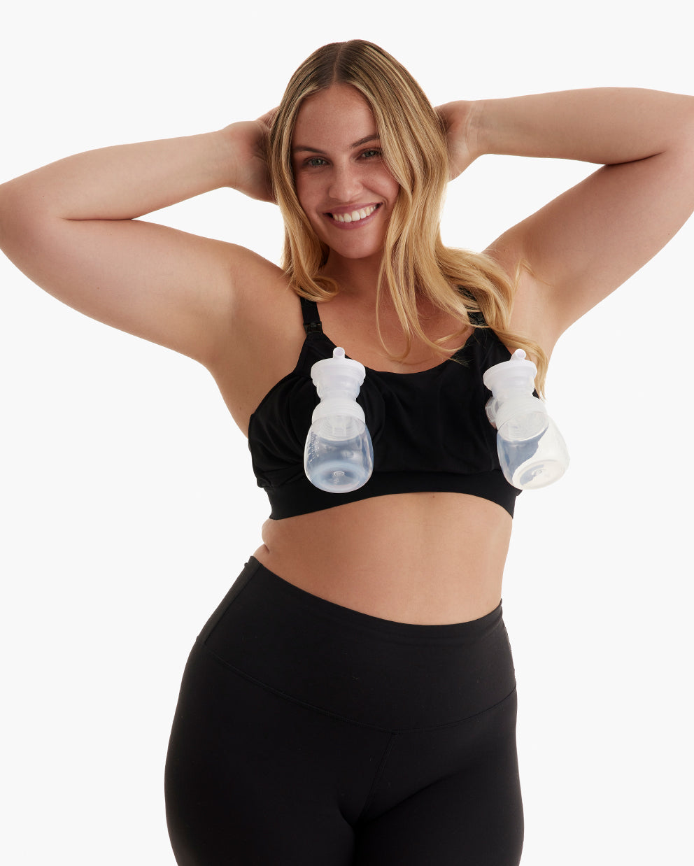 Smiling blonde demonstrates hands-free pumping in black YN08 bra with adjustable straps & wide underband.
